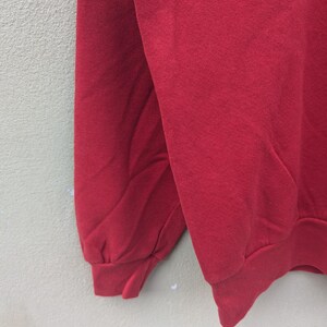 May include: A red long-sleeved sweatshirt with a ribbed cuff.
