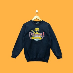 May include: Black sweatshirt with a yellow snake graphic and the word "VENOMA" in red letters.