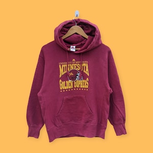 May include: A maroon hooded sweatshirt with a gold graphic of the University of Minnesota Golden Gophers logo. The logo features a football helmet with the letter "M" on it.
