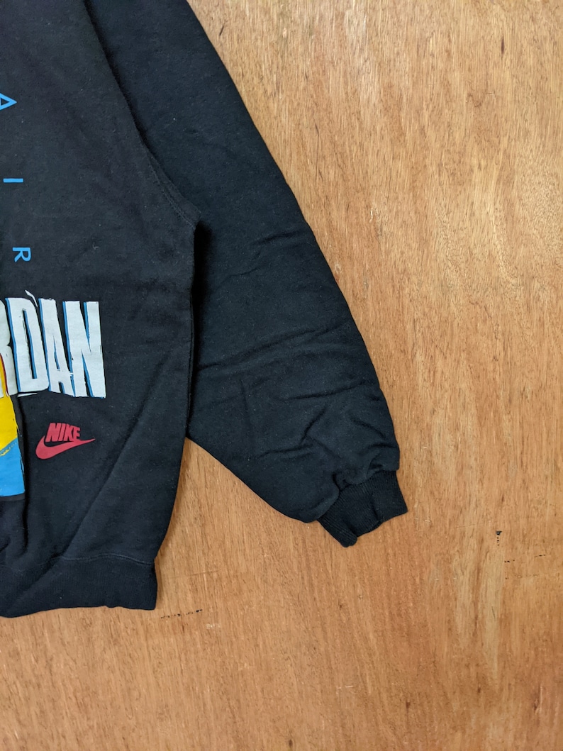 May include: Black sweatshirt with a colorful graphic print of the word "AIR JORDAN" and the Nike logo.