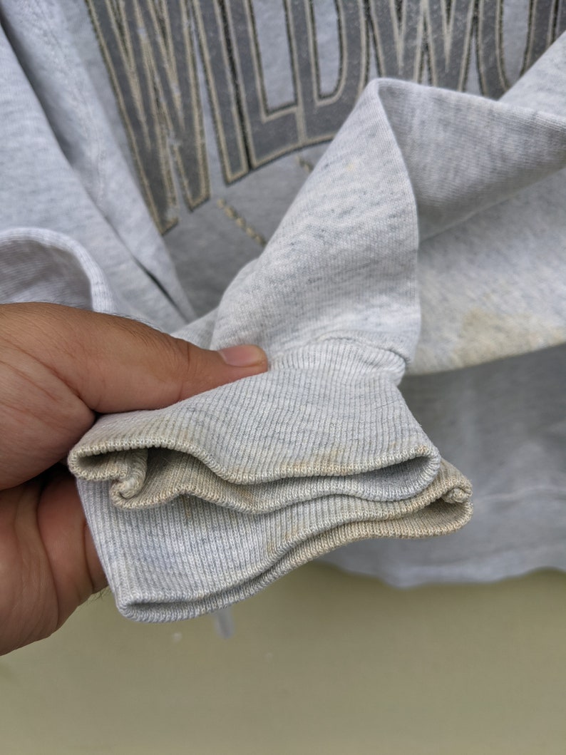 May include: Close-up of the gray ribbed cuff of a sweatshirt. The cuff is folded over twice, showing the inside of the fabric.