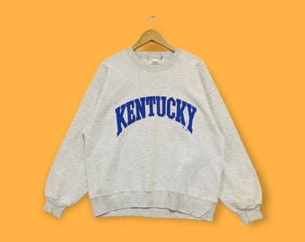 May include: A gray sweatshirt with a blue "Kentucky" logo printed on the front.