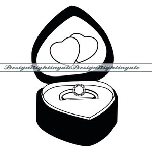 Puede incluir: Una caja de anillo negra en forma de corazón con un anillo dentro y dos corazones en la tapa.