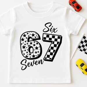 Pu&ograve; includere: T-shirt bianca con i numeri "6" e "7" in nero. Il numero "6" &egrave; riempito di stelle, e il "7" ha un motivo a scacchi. Le parole "Six" e "Seven" sono scritte in corsivo. Sono presenti anche piccole macchinine giocattolo e una bandiera a scacchi.