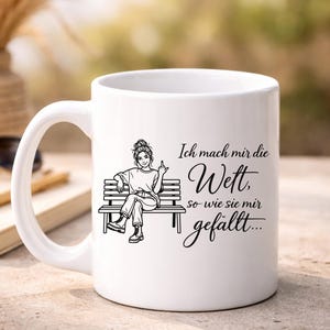 Puede incluir: Taza de cer&aacute;mica blanca con una ilustraci&oacute;n negra de una persona sentada en un banco, mostrando el dedo medio. La taza tiene el texto alem&aacute;n "Ich mach mir die Wett, so wie sie mir gef&auml;llt..."