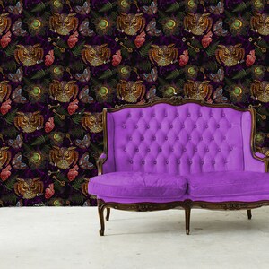 May include: A purple velvet tufted sofa sits in front of a dark purple wallpaper with a repeating pattern of owls, hearts, keys, and ferns.