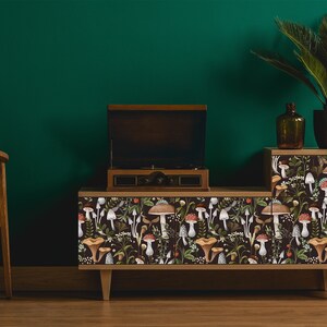 Dark botanical mushroom fabric peel and stick dollhouse wallpaper on record player cabinet with plant and chair