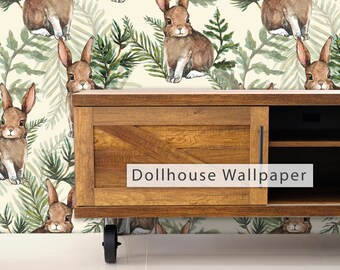 May include: A wooden entertainment center with a light brown finish and black hardware. The entertainment center has a shelf and a cabinet door. The entertainment center is in front of a wallpaper with a pattern of brown rabbits and green leaves on a cream background. The wallpaper has the text "Dollhouse Wallpaper" printed on it.