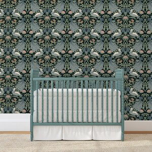 May include: A teal blue crib with white bedding in front of a black and green wallpaper with a repeating pattern of stylized peacocks and flowers.