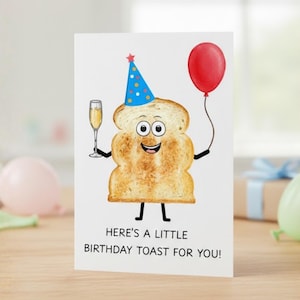 May include: A birthday greeting card featuring a cartoon slice of toast with a party hat and a red balloon. The toast holds a champagne glass. Text reads, "Here's a little birthday toast for you!"