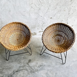Può includere: Due sedie rotonde in vimini con gambe a forcina in metallo nero. Le sedie hanno un colore marrone naturale e un design intrecciato. Le sedie sono adatte per uso interno o esterno.