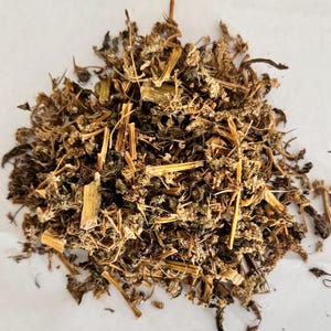 Könnte beinhalten: Nahaufnahme eines Haufens getrockneter Kräuter, der eine Mischung aus Braun-, Beige- und Grüntönen aufweist. Die Zusammensetzung umfasst Stängel, Blätter und kleine blütenartige Strukturen, was auf ein natürliches, organisches Produkt hindeutet.