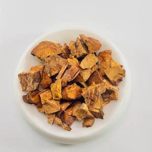 Può includere: Un piatto di ceramica bianca pieno di pezzi di corteccia marroni e secchi di forma irregolare.