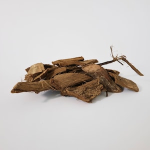 May include: A pile of brown, dried, and shredded bark. The bark is in various shapes and sizes, with some pieces being long and thin, while others are short and thick.