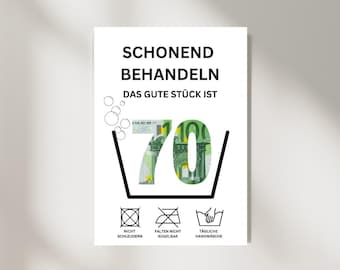 May include: A white sign with black text that reads "Schonend Behandeln Das Gute Stück Ist 70" with a 70 euro bill in the number 70. The sign also has three symbols: a circle with a cross through it, a square with a cross through it, and a bucket with a hand in it. The text below the symbols reads "Nicht Schleudern, Falten Nicht Bügelbar, Tägliche Handwäsche."
