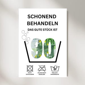 Könnte beinhalten: Ein weißes Schild mit schwarzem Text, auf dem "Schonend Behandeln Das Gute Stück Ist 90" steht, mit einem 90-Euro-Schein in einem Waschmaschinensymbol. Unter dem Symbol befinden sich drei Waschanweisungen: "Nicht Schleudern", "Falten Nicht Bügelbar" und "Tägliche Handwäsche".