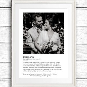 May include: Black and white framed print featuring a couple embracing. The print includes the German word "Ehemann" and a definition. The couple is dressed in formal attire, with the woman holding a bouquet of flowers.