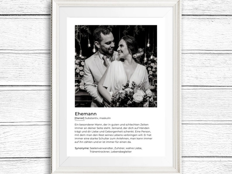 May include: Black and white framed print featuring a couple embracing. The print includes the German word "Ehemann" and a definition. The couple is dressed in formal attire, with the woman holding a bouquet of flowers.