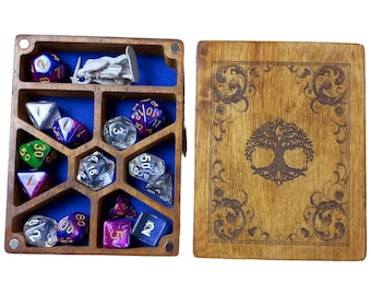 May include: A wooden box with a blue felt interior and a tree of life design on the lid. The box contains a set of dice in various colours and materials, including clear, green, purple, and silver.