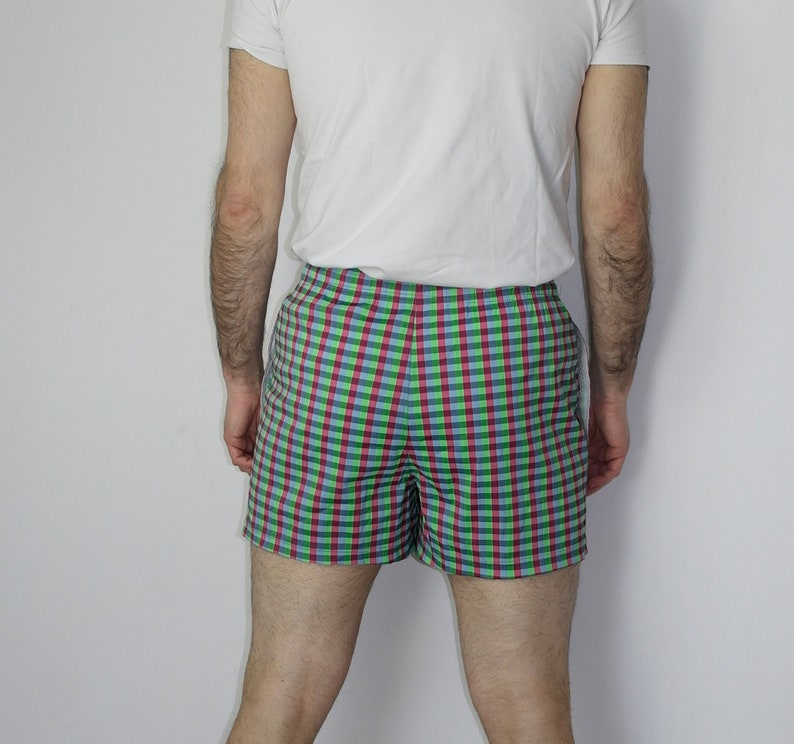 May include: A pair of checkered shorts with a green, blue, and red pattern. The shorts are made of a lightweight fabric and have a comfortable fit.
