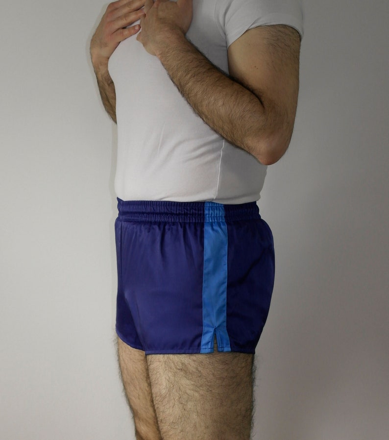 Op de afbeelding: Blauwe sport shorts met een blauwe streep aan de zijkant. De shorts hebben een elastische tailleband en een trekkoord.