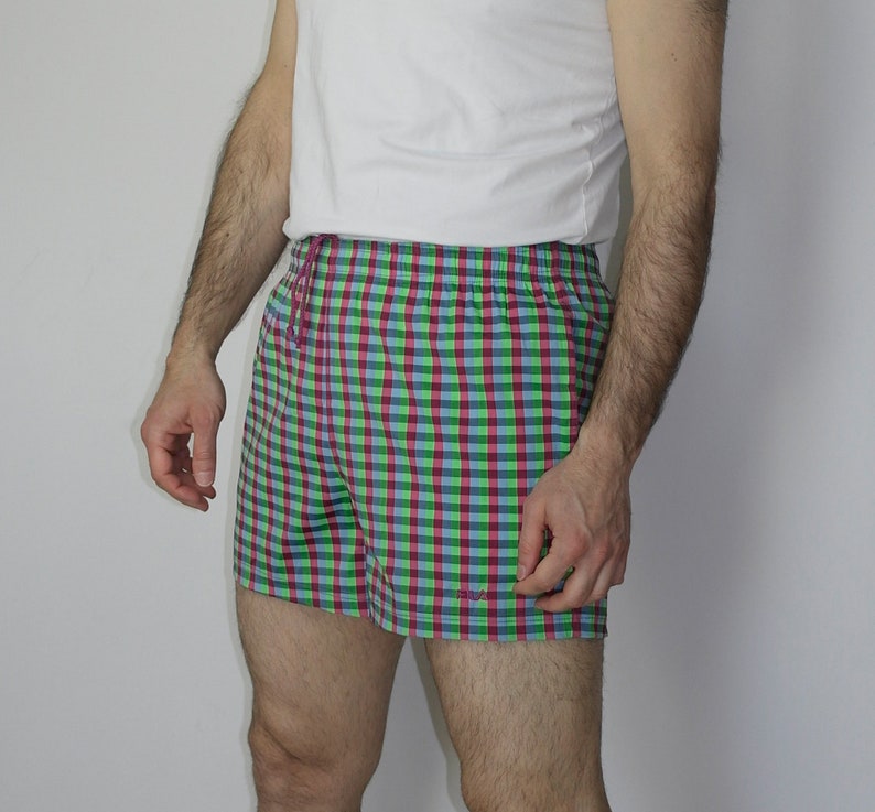 May include: Green, pink, and blue plaid shorts with a white drawstring.