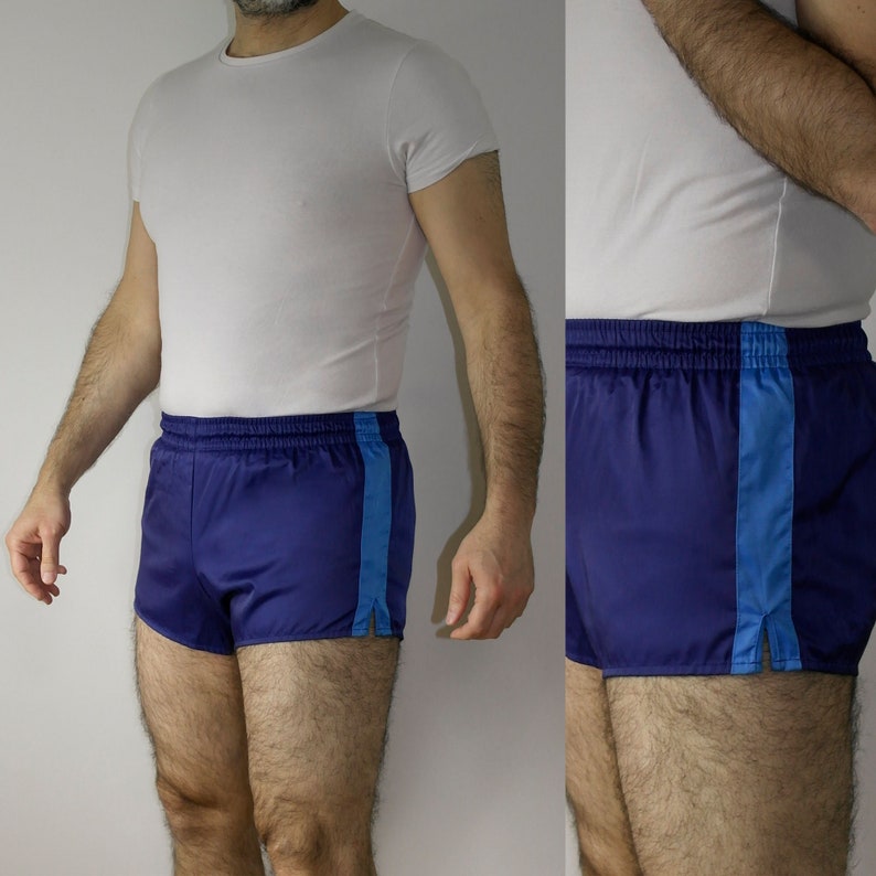 Op de afbeelding: Een blauwe sportbroek met een witte tailleband en blauwe bies. De broek heeft een zijsplit aan elk been.