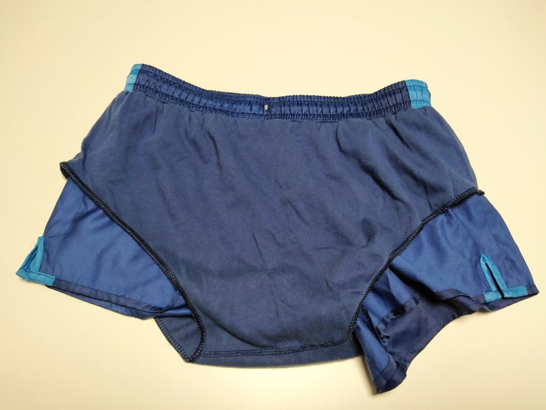 Op de afbeelding: Blauwe hardloopshorts met een zwarte tailleband en blauwe bies. De shorts hebben een ingebouwde voering.