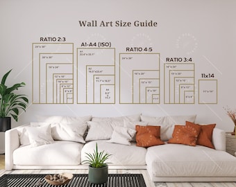 May include: A wall art size guide with different ratios and sizes in inches. The guide shows the standard sizes for wall art, including 2:3, 4:5, 3:4, and 11x14 ratios. The guide is displayed on a white wall with a white sofa and a green plant in the foreground.