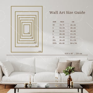 Puede incluir: Una guía de tamaños de arte de pared con un sofá blanco y una mesa en primer plano. La guía muestra diferentes tamaños de arte de pared en pulgadas y centímetros, de XS a XXXL. El sofá mide 90 pulgadas o 228 centímetros de largo.