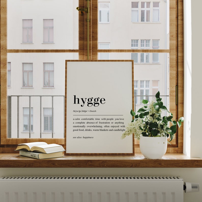 May include: A black and white printable wall art print with the word "hygge" defined as a calm comfortable time with people you love, a complete absence of frustration or anything emotionally overwhelming, often enjoyed with good food, drinks, warm blankets and candlelight. See also: happiness.