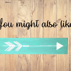 May include: A teal blue wooden sign with a white arrow pointing to the right. The sign has the text "You might also like..." written in black cursive.