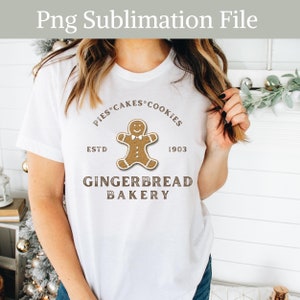 May include: White t-shirt with a brown gingerbread man graphic and the text "Pies Cakes Cookies Est'd 1903 Gingerbread Bakery".