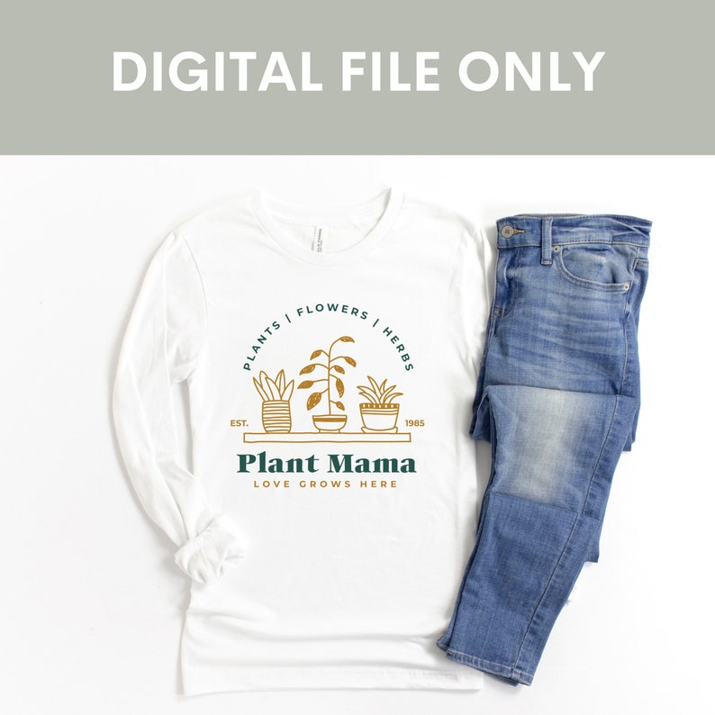 Puede incluir: Camiseta blanca de manga larga con un gr&aacute;fico verde y dorado de plantas en maceta y el texto "PLANTS | FLOWERS | HERBS", "EST. 1985", "Plant Mama" y "LOVE GROWS HERE".