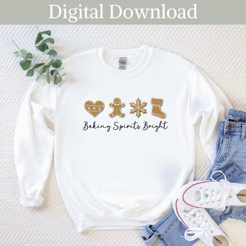 May include: White sweatshirt with a gingerbread cookie design and the text "Baking Spirits Bright".