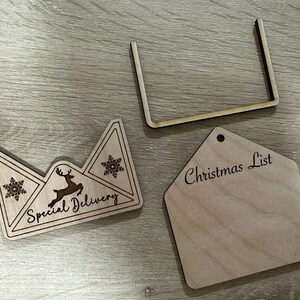 May include: A wooden Christmas list tag with the text "Christmas List" and a wooden envelope with the text "Special Delivery" and a reindeer and snowflake design.