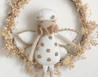 May include: A white crocheted angel with gold glitter accents and a brown crocheted bow. The angel is hanging on a dried flower wreath.