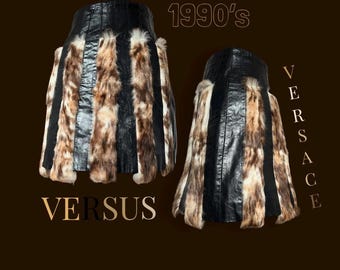 May include: A black leather and fur mini skirt with vertical stripes. The skirt is labeled "VERSUS" and "1990's".