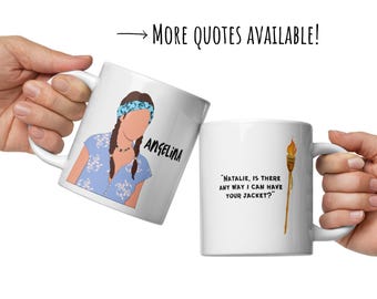May include: Two white ceramic mugs with black text and illustrations. One mug features a cartoon of a woman and the name "ANGELINA". The other mug has a quote and a torch illustration. The text reads "MORE QUOTES AVAILABLE!"