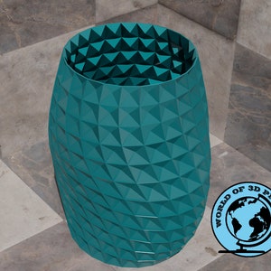 May include: A teal blue vase with a geometric pattern. The vase is made of a 3D printed material.