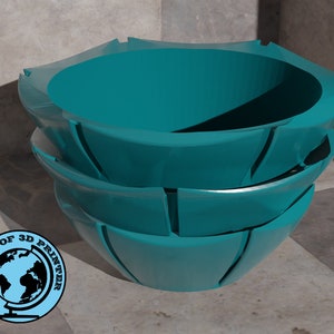Könnte beinhalten: Eine tealblaue Keramikschale mit einem einzigartigen, segmentierten Design. Die Schale ist auf sich selbst gestapelt, wodurch ein geschichteter Effekt entsteht.