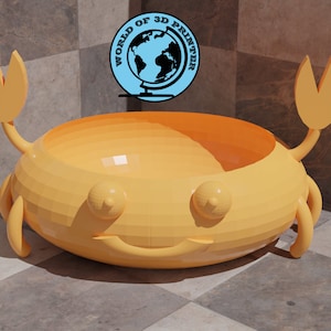 May include: A yellow 3D printed crab-shaped bowl with a smiling face. The bowl is sitting on a checkered floor.