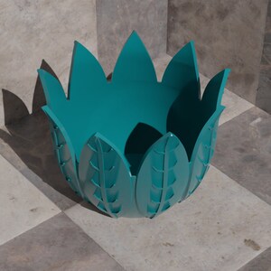 K&ouml;nnte beinhalten: T&uuml;rkise Keramikvase mit einem einzigartigen Blattdesign. Die Vase hat eine breite &Ouml;ffnung und einen abgerundeten Boden.