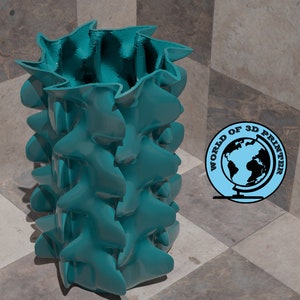May include: A teal blue vase with a unique, organic, and textured design. The vase is made of 3D printed plastic and has a wavy, undulating surface.