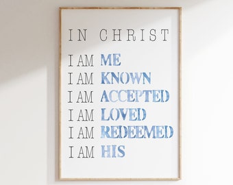 May include: A framed print featuring the words "IN CHRIST" at the top, followed by a list of affirmations in black and blue watercolour lettering. The text reads "I AM ME, I AM KNOWN, I AM ACCEPTED, I AM LOVED, I AM REDEEMED, I AM HIS."