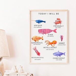 May include: A framed watercolor print with the text "TODAY I WILL BE" and various sea creatures, including a narwhal, whale, crab, walrus, octopus, jellyfish, squid, and shark. The print is in a light wood frame and is displayed on a dresser.
