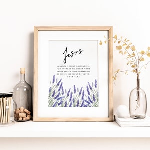 K&ouml;nnte beinhalten: Gerahmter Druck mit dem Wort "Jesus" in eleganter Schrift. Der Druck enth&auml;lt einen Bibelvers und Lavendel-Illustrationen. Der Rahmen ist aus hellem Holz, und die Gesamt&auml;sthetik ist minimalistisch und heiter.