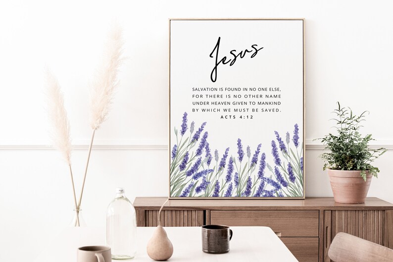 K&ouml;nnte beinhalten: Gerahmter Druck mit dem Wort "Jesus" in Schreibschrift. Darunter ist ein Bibelvers &uuml;ber einer Aquarellillustration von lila Lavendel gedruckt. Der Druck wird auf einem Holzschrank ausgestellt.