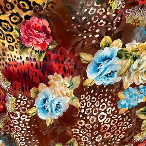 May include: A brown fabric with a colorful floral pattern. The fabric features a mix of red, blue, yellow, and white flowers, as well as a leopard print pattern.