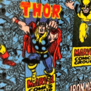 Peut inclure: Un tissu bleu avec un motif de bande dessin&eacute;e mettant en sc&egrave;ne des personnages Marvel comme Thor, Wolverine et Iron Man. Le tissu porte l'inscription "Marvel Comics Group".